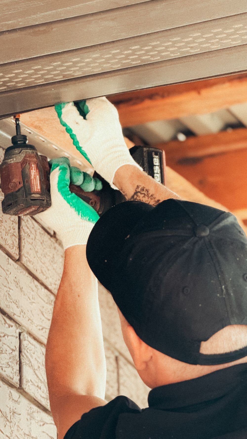 Hausmeister bei Montagearbeit an einer Fassade